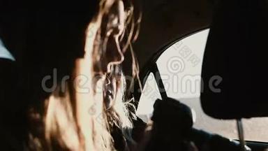 在车里看。 旅游妇女乘车，在窗外拍摄日落景观。